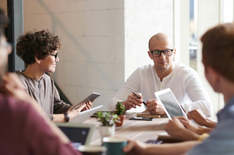 Groupe de personnes discutant ensemble autour d'une table